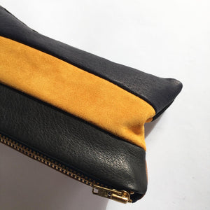 Lille clutch i gul, sort, blå og cognac skind.