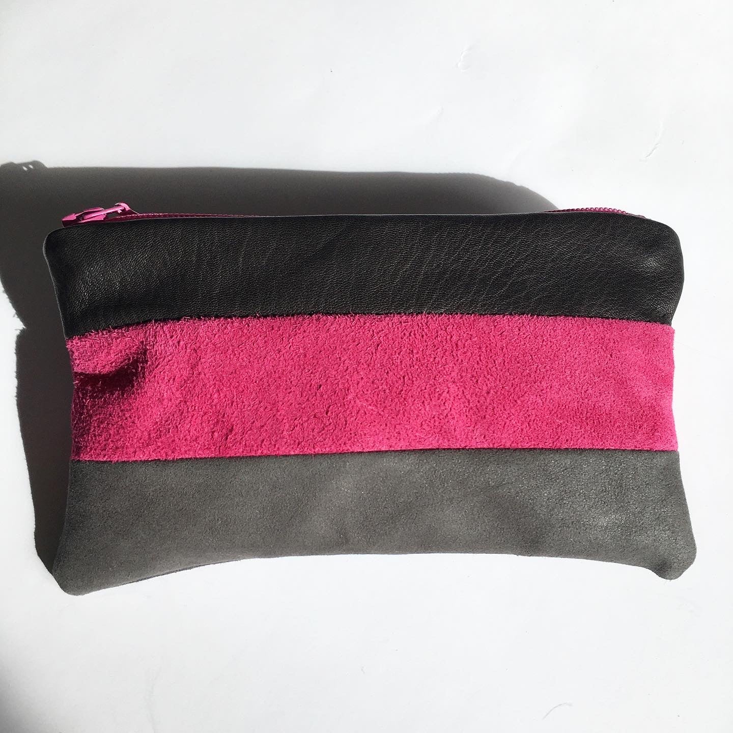 Lille clutch i grå, sort og pink skind.