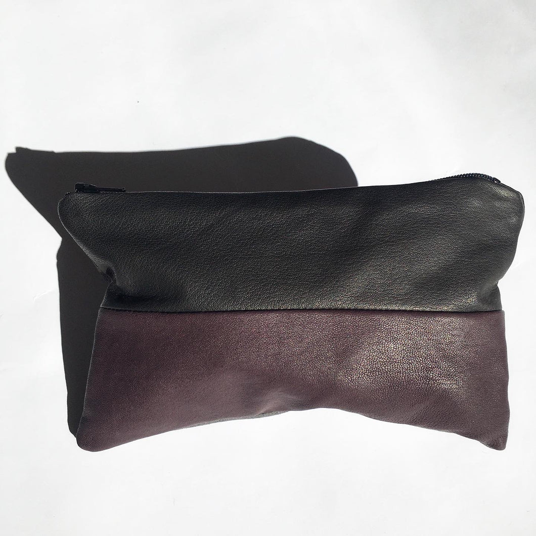 Lille clutch i sort, plum og grå.