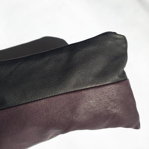 Lille clutch i sort, plum og grå.